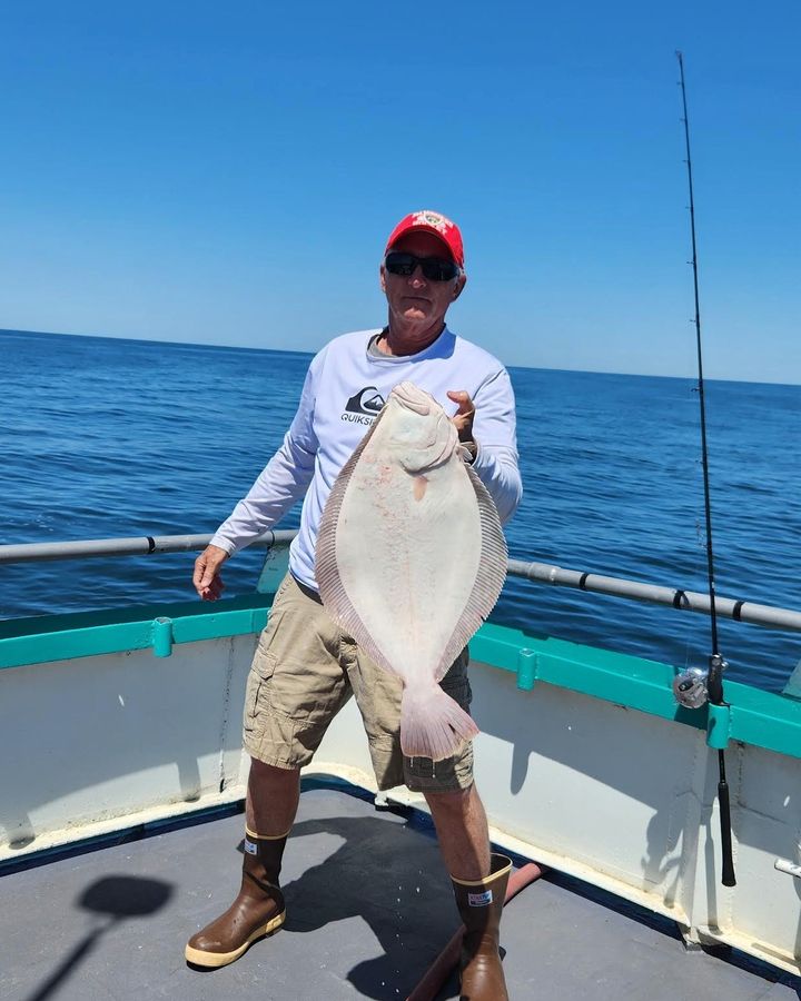 a man standing next to a body of water