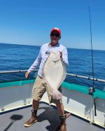 a man standing next to a body of water