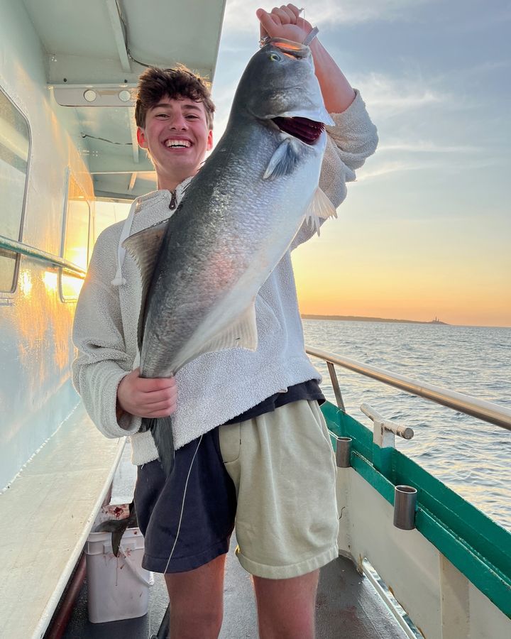 a person holding a fish on a boat