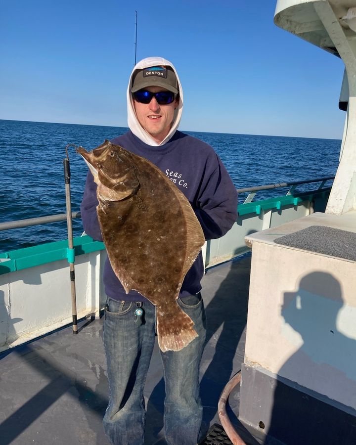 a person holding a fish on a boat in the water