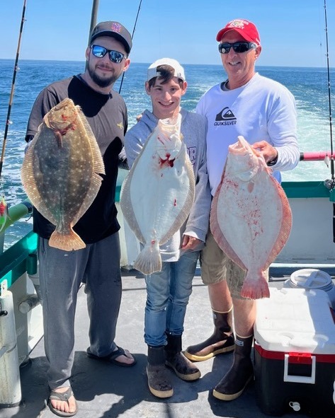 a group of people standing next to a person holding a fish