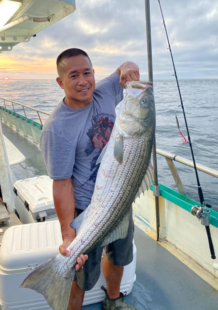 a man holding a fish on a boat