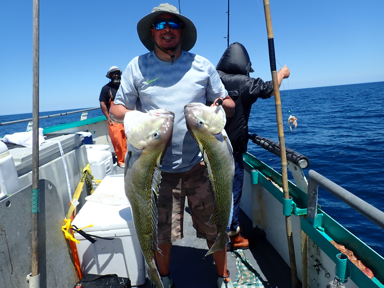 a man holding a fish on a boat