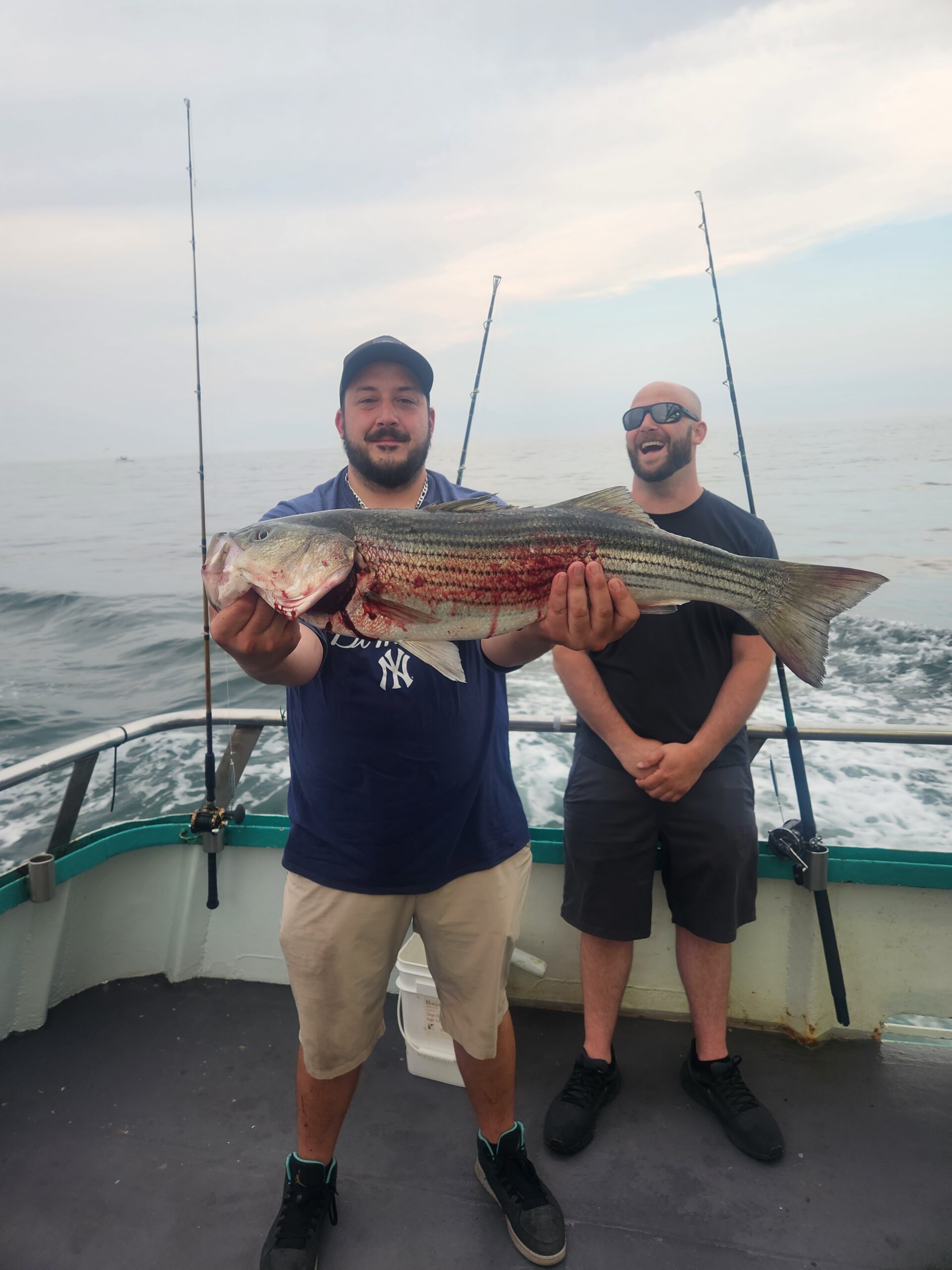 a man holding a fish on a boat posing for the camera
