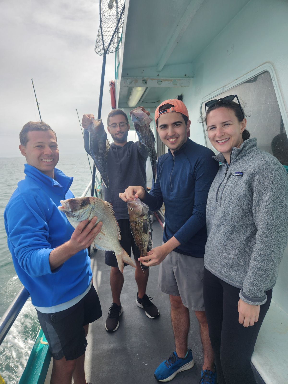a group of people standing next to a person holding a fish