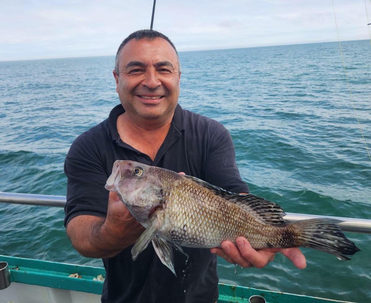 a man holding a fish in the water