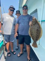 a person holding a fish posing for the camera