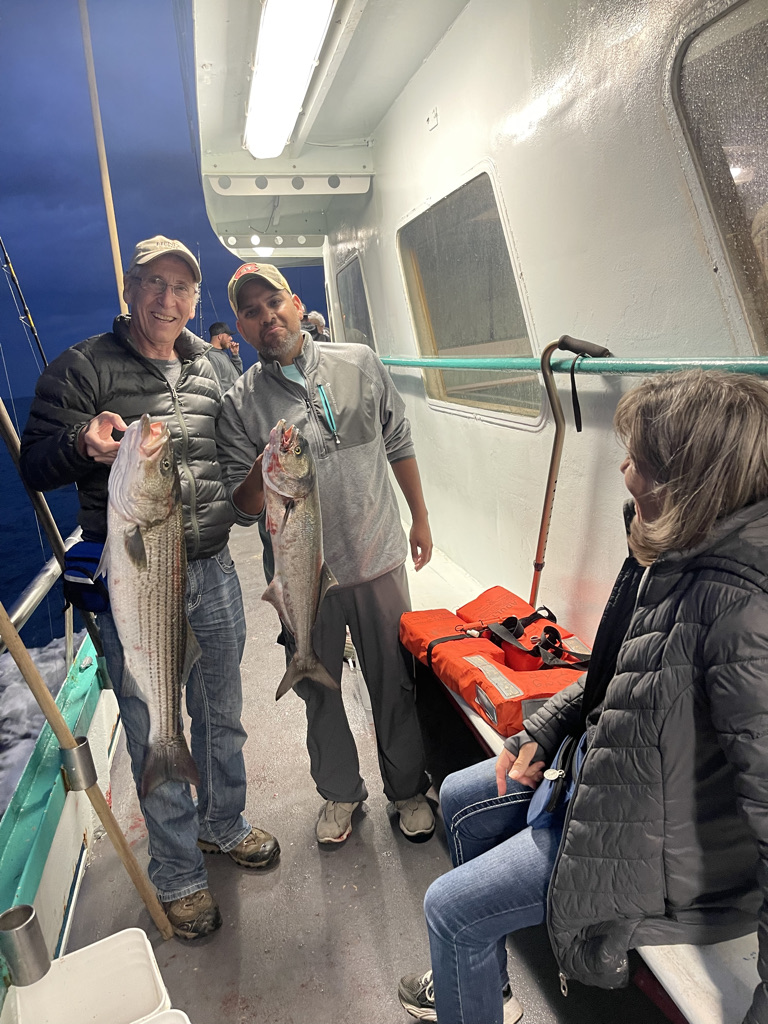 a group of people standing in front of a fish