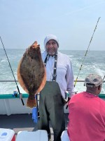 a man holding a fish on a boat