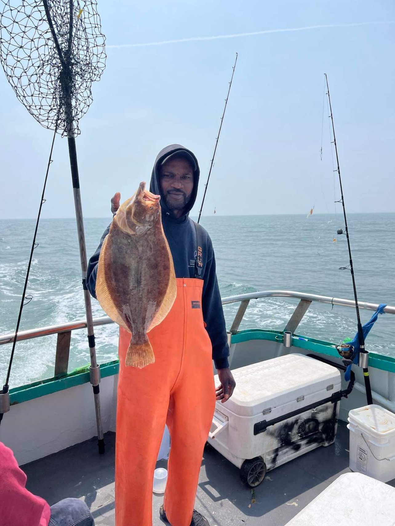 a person holding a fish on a boat in the water