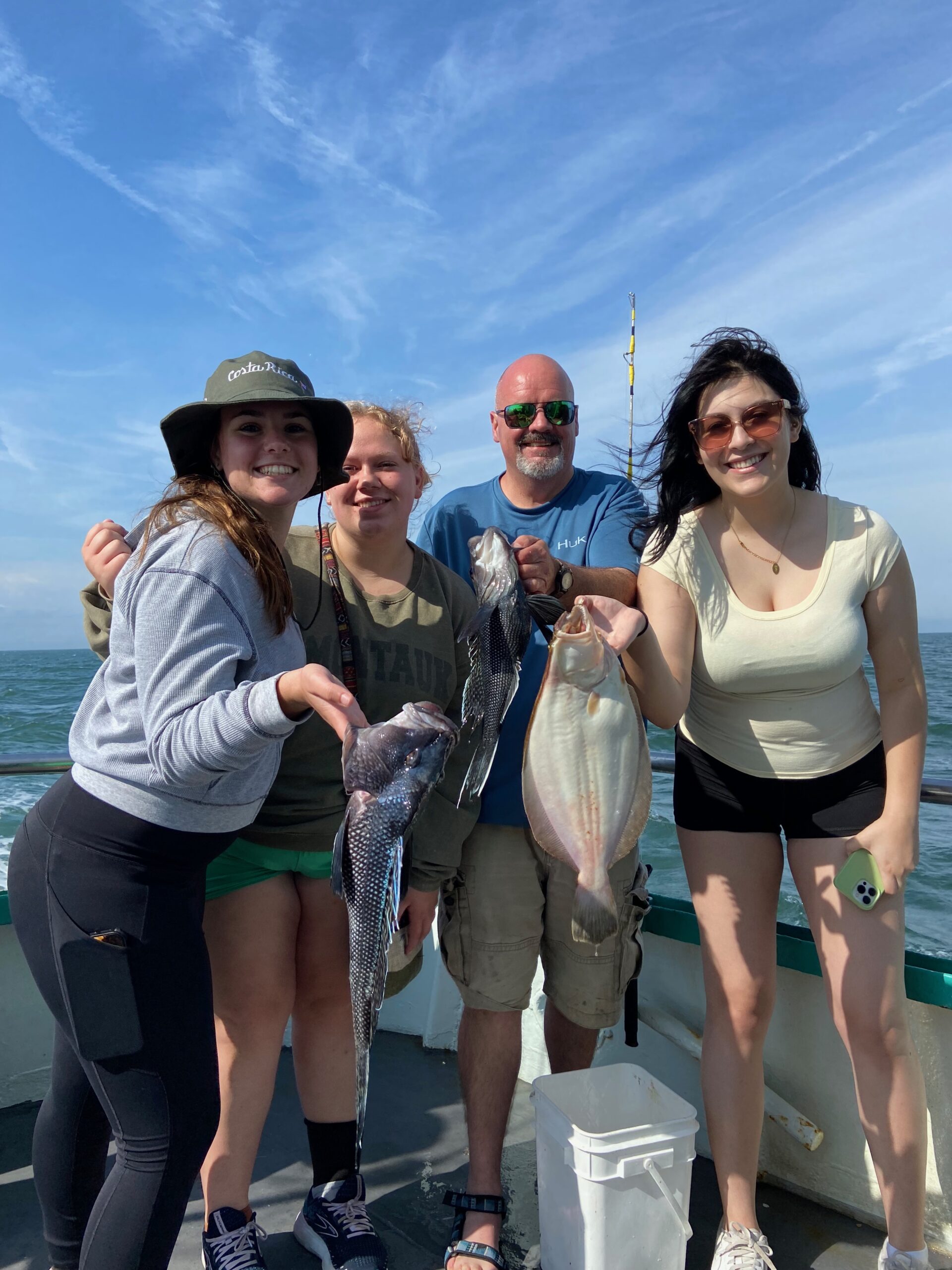 a group of people standing next to a woman holding a fish