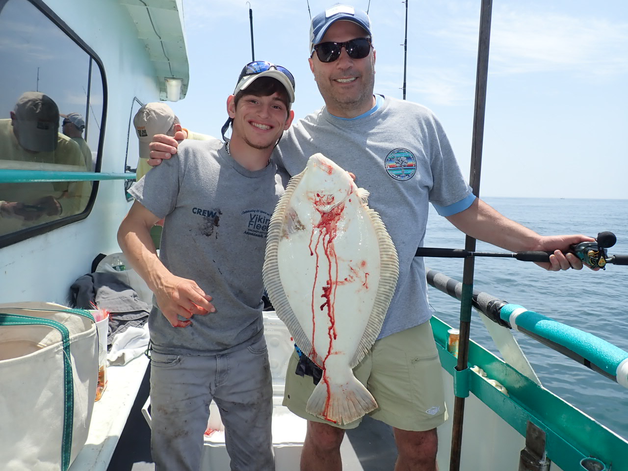 a man holding a fish on a boat