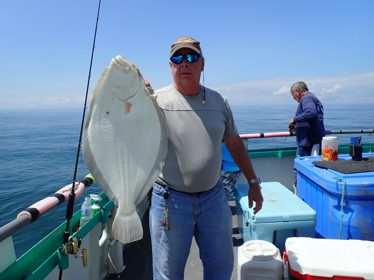 a man holding a fish on a boat in the water