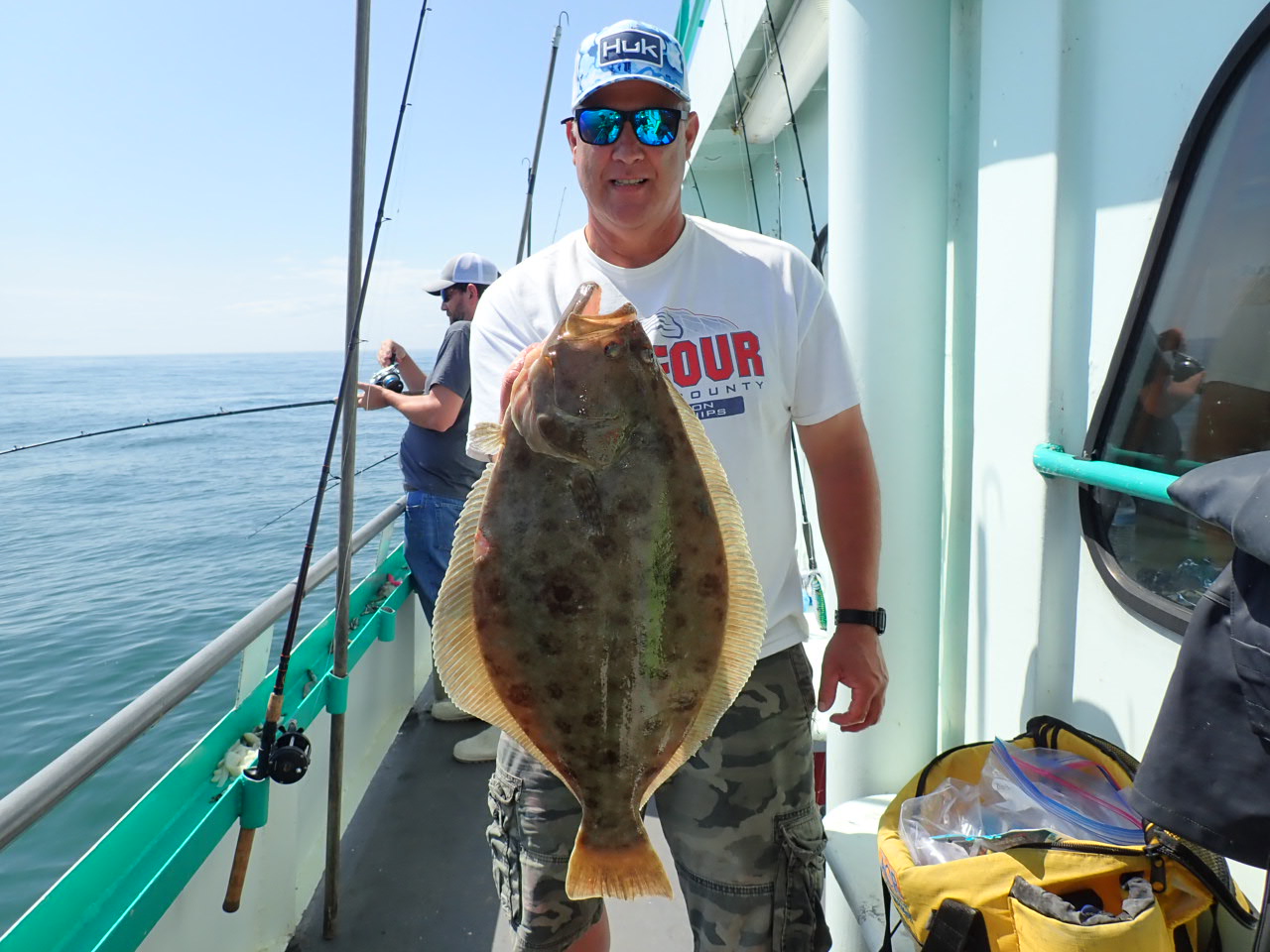a man holding a fish on a boat