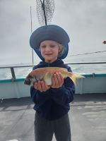 a young boy holding a fish