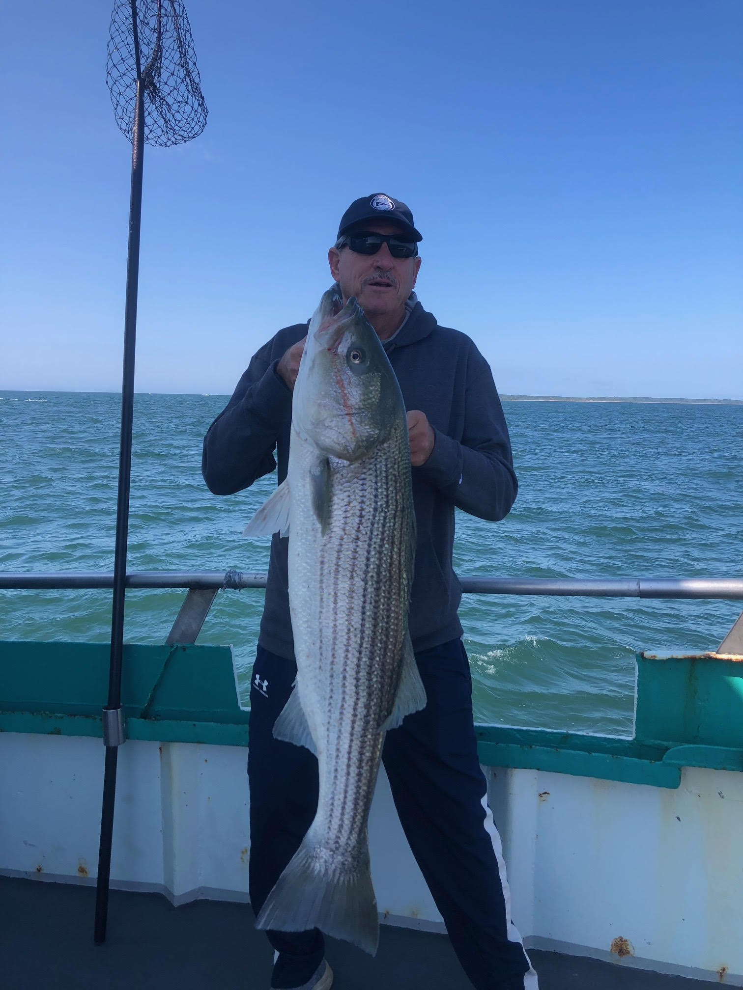 a person holding a fish on a boat in a body of water