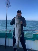 a person holding a fish on a boat in a body of water