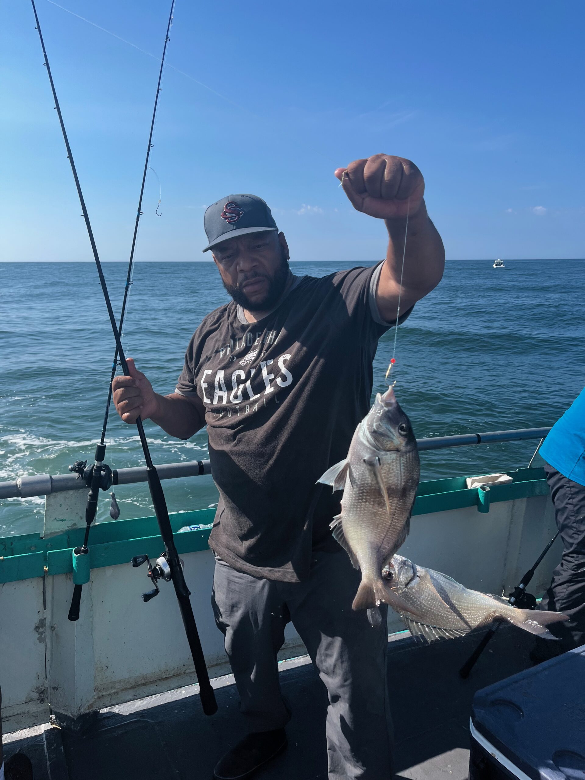 a man holding a fish on a boat