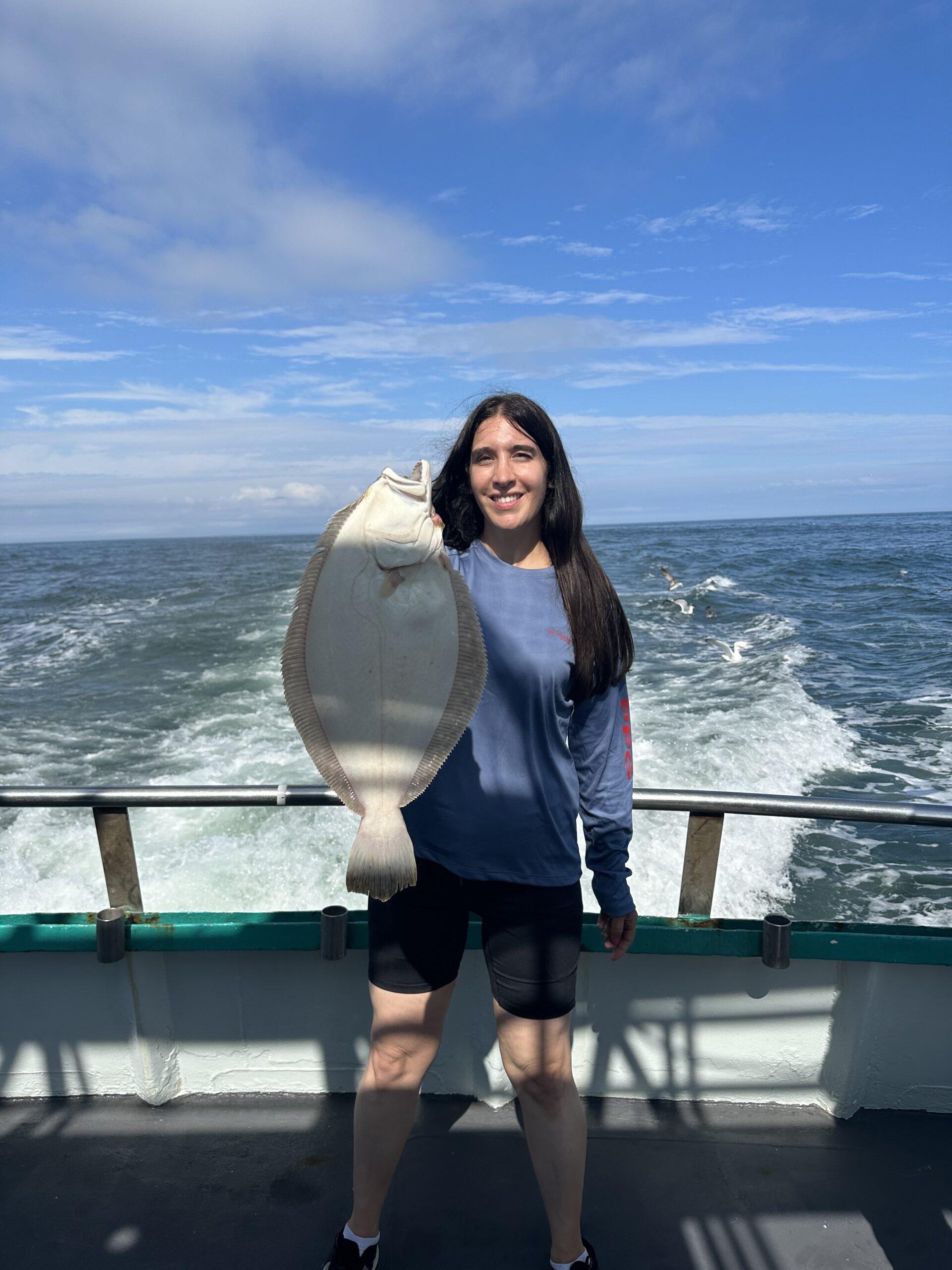 a woman standing in front of a body of water