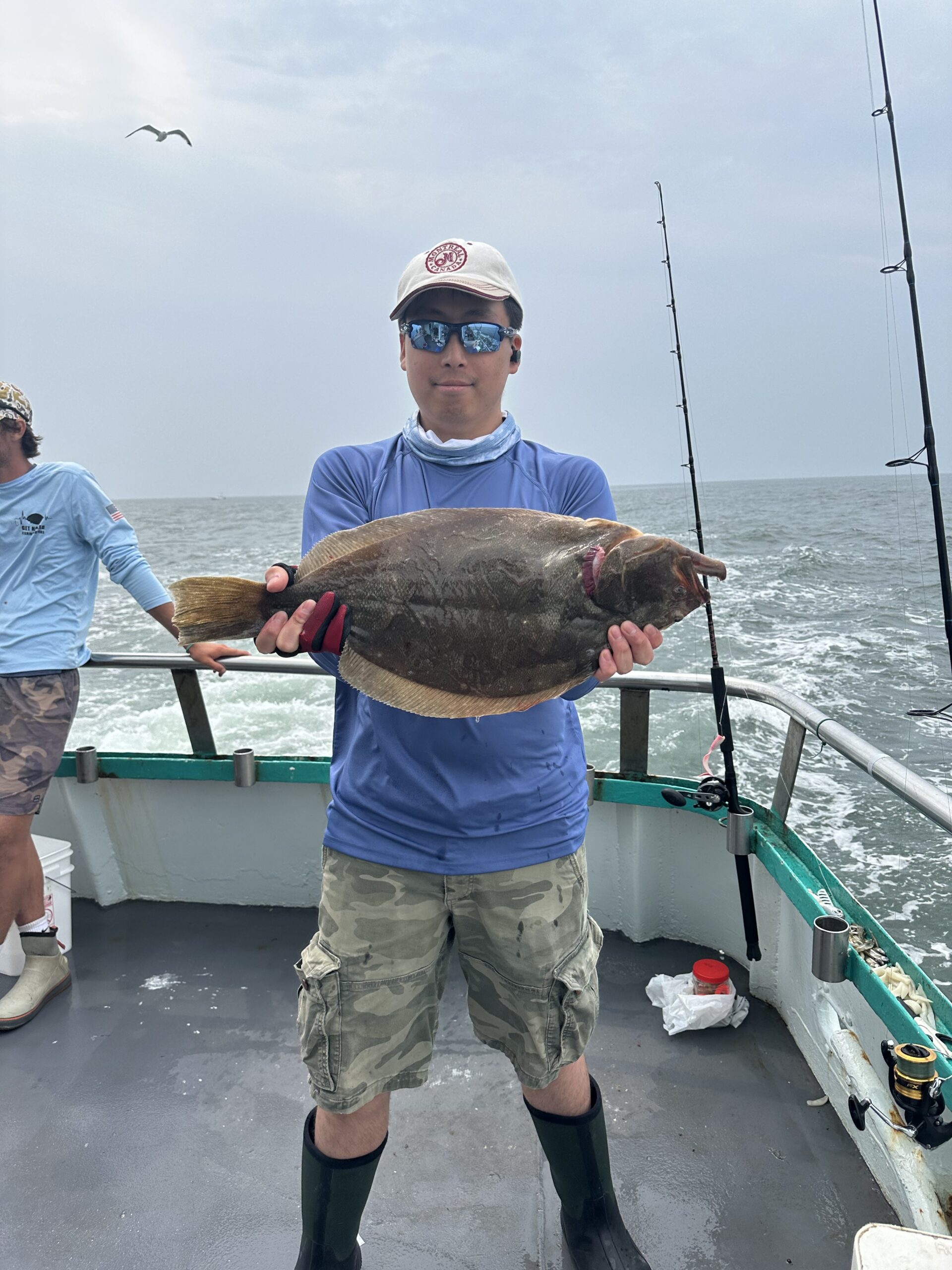 a man holding a fish on a boat in the water