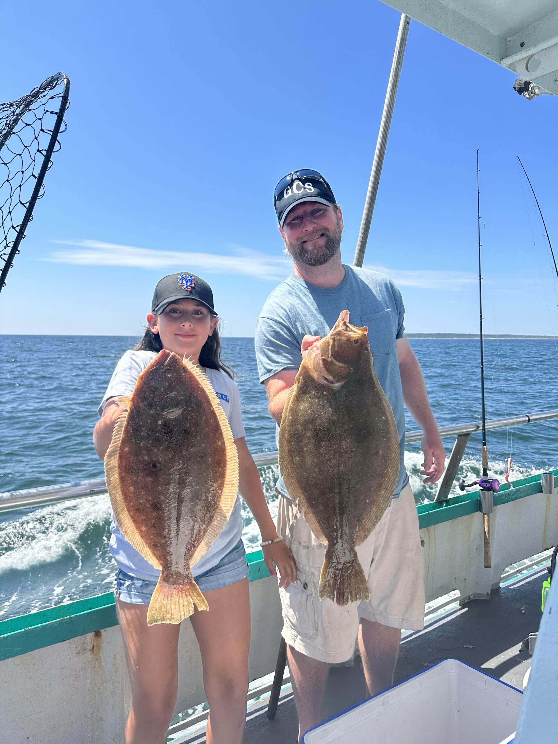 a man holding a fish on a boat in the water