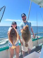 a man holding a fish on a boat in the water