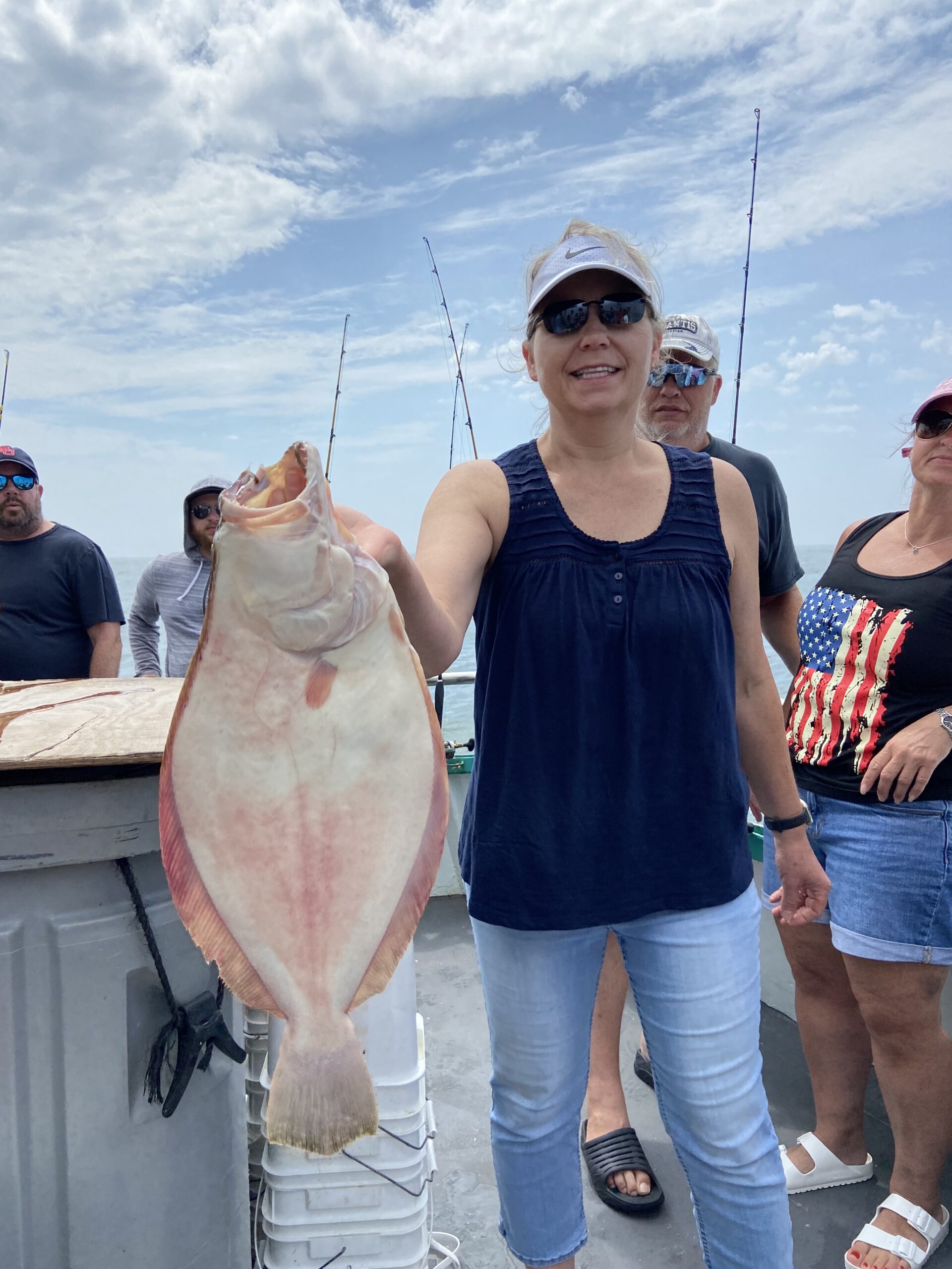 a group of people standing next to a person holding a fish