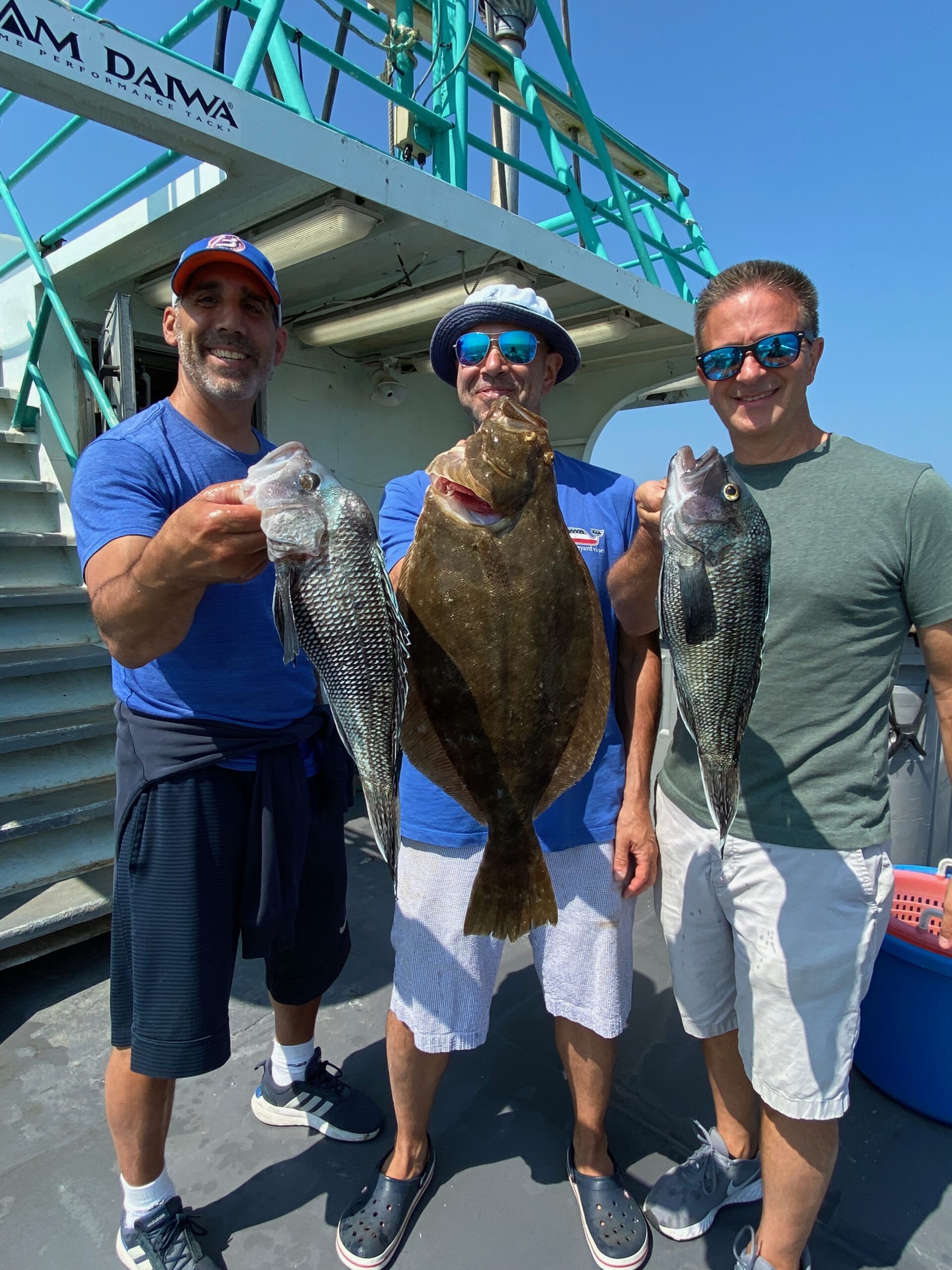 a group of people standing next to a man holding a fish