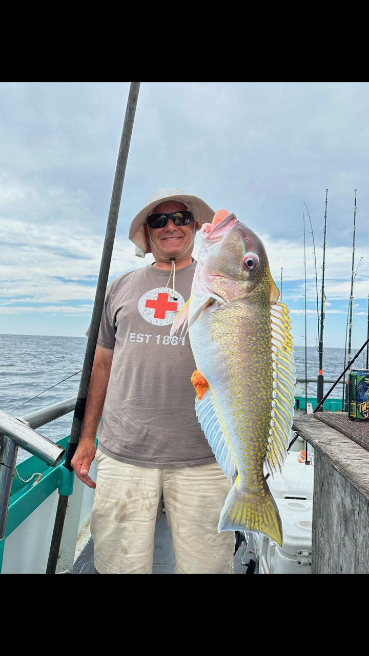 a man holding a fish in the water