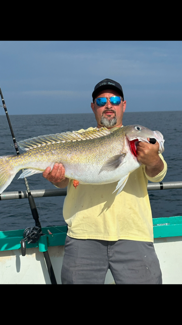 a man holding a fish in the water