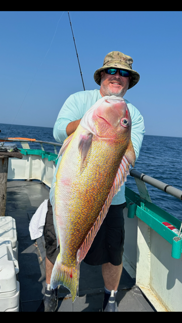 a man holding a fish on a boat