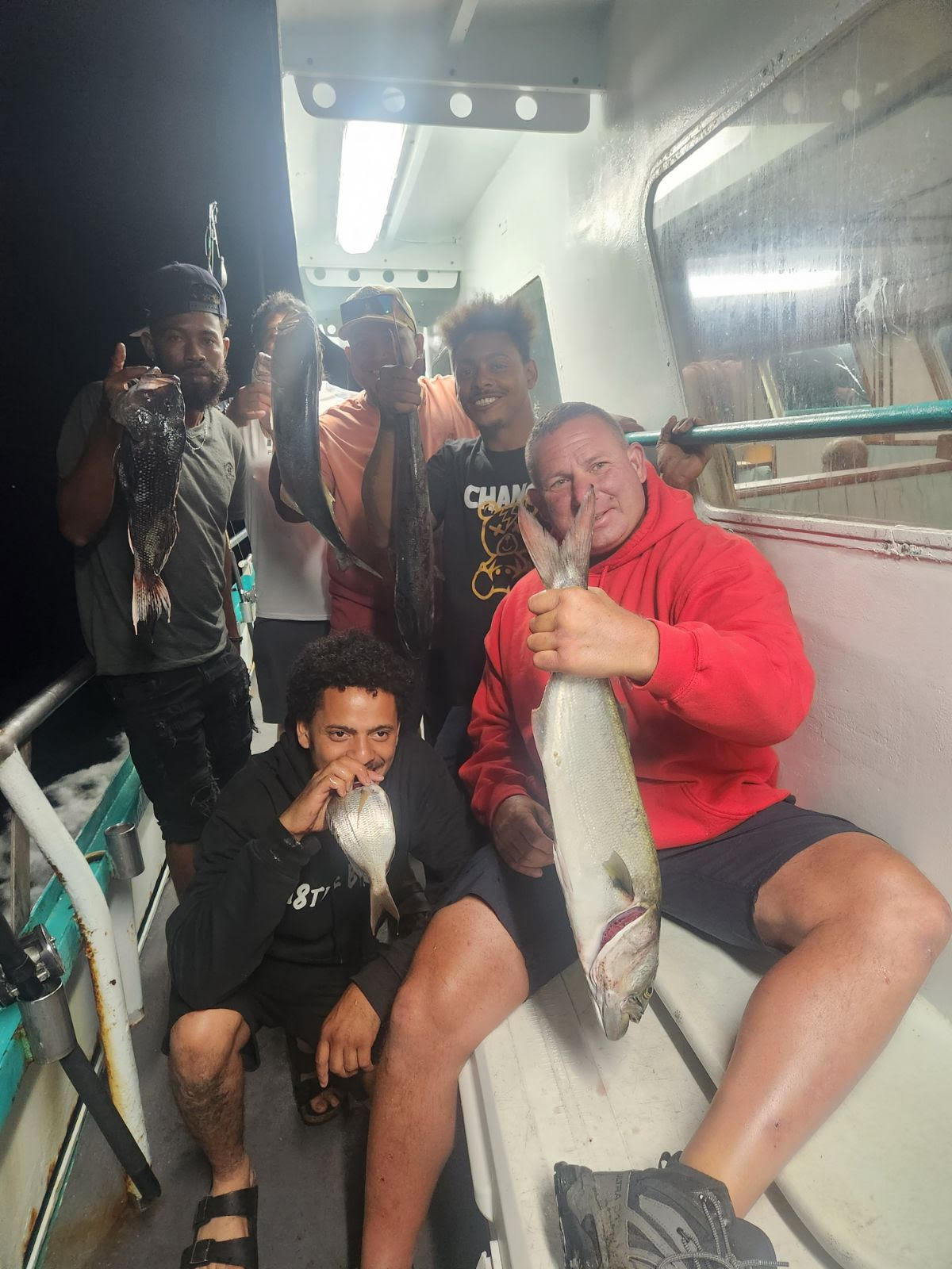 a group of people standing next to a person holding a fish