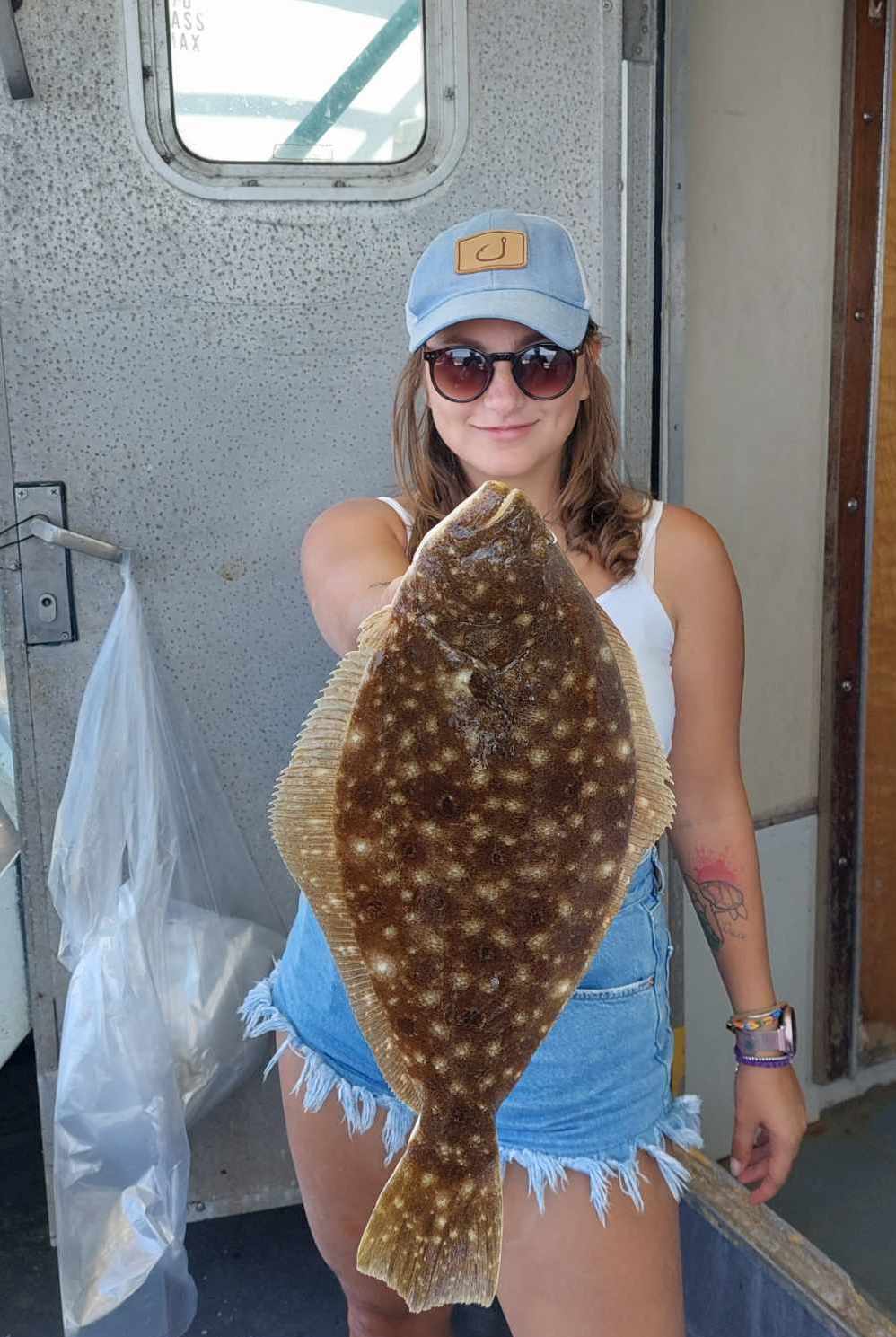 a person wearing a hat and sunglasses posing for the camera