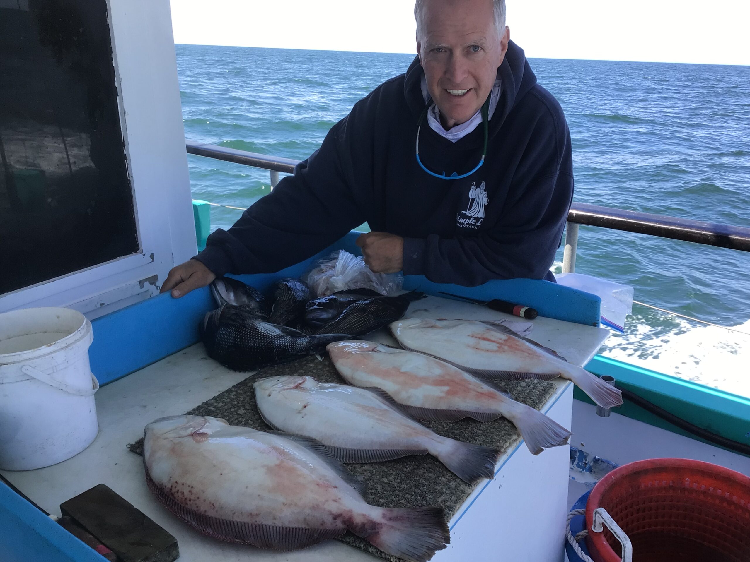 a man holding a fish on a boat in the water