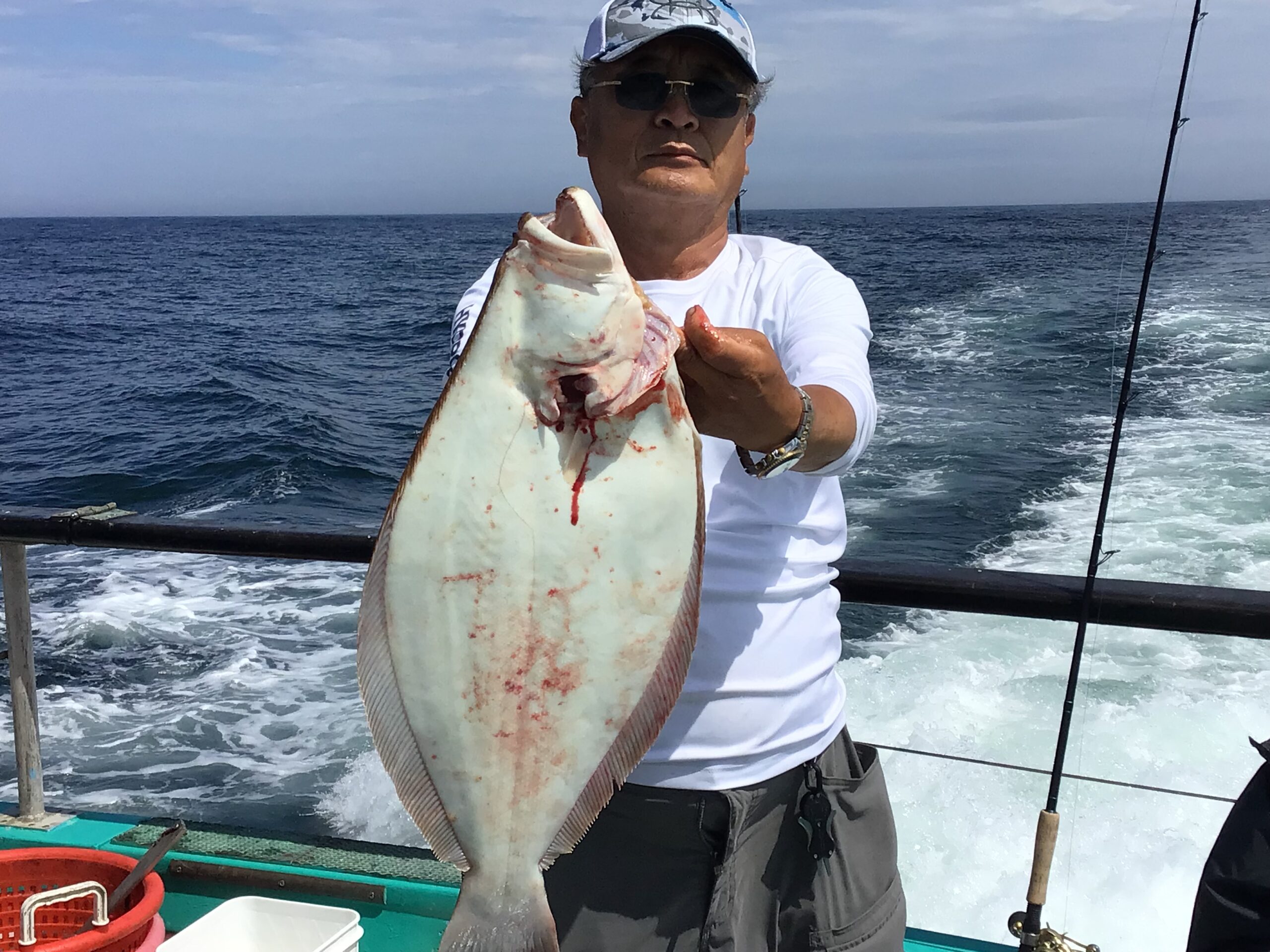 a man holding a fish on a boat in the water