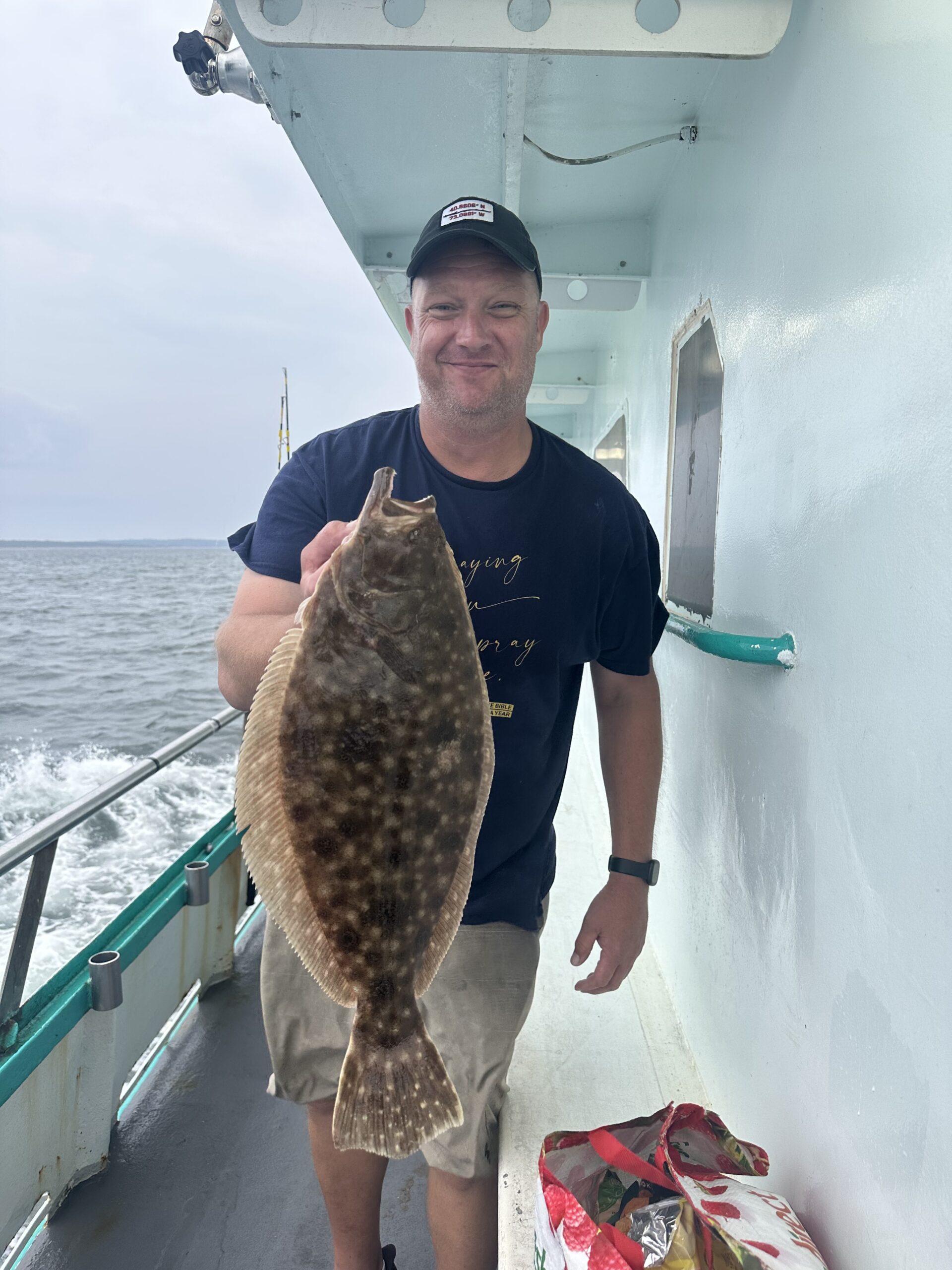 a man holding a fish on a boat in the water