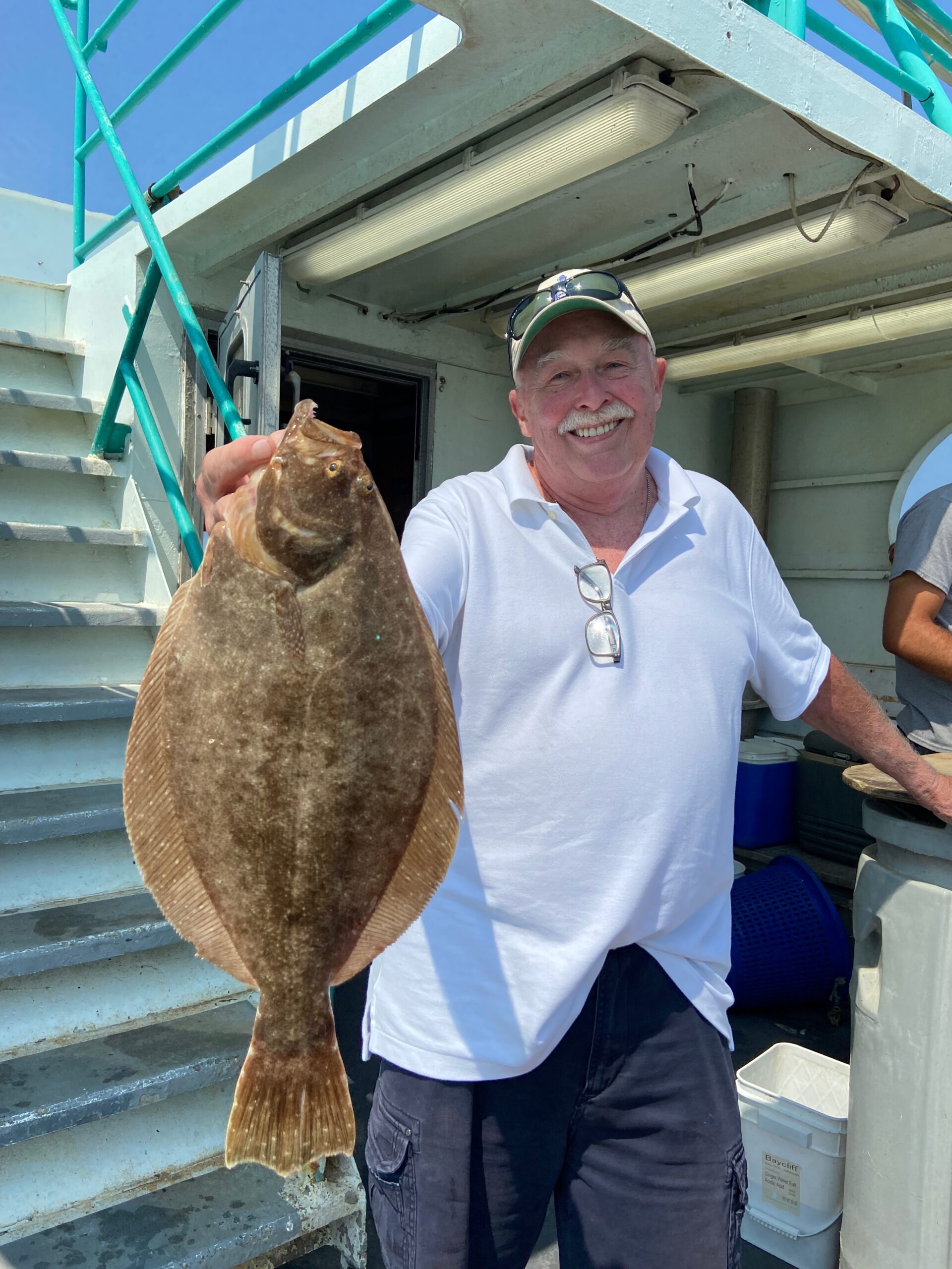 a man holding a fish in front of a building