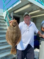 a man holding a fish in front of a building