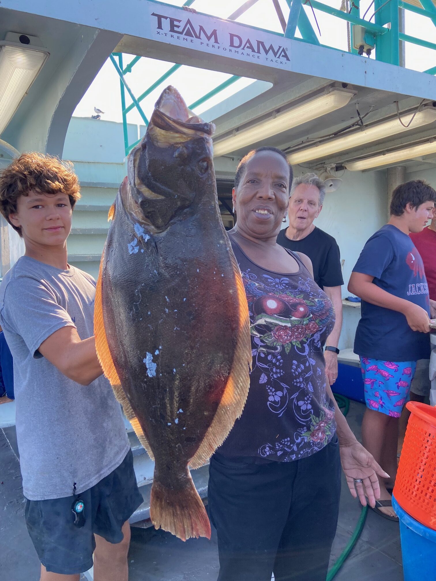 a group of people standing in front of a fish