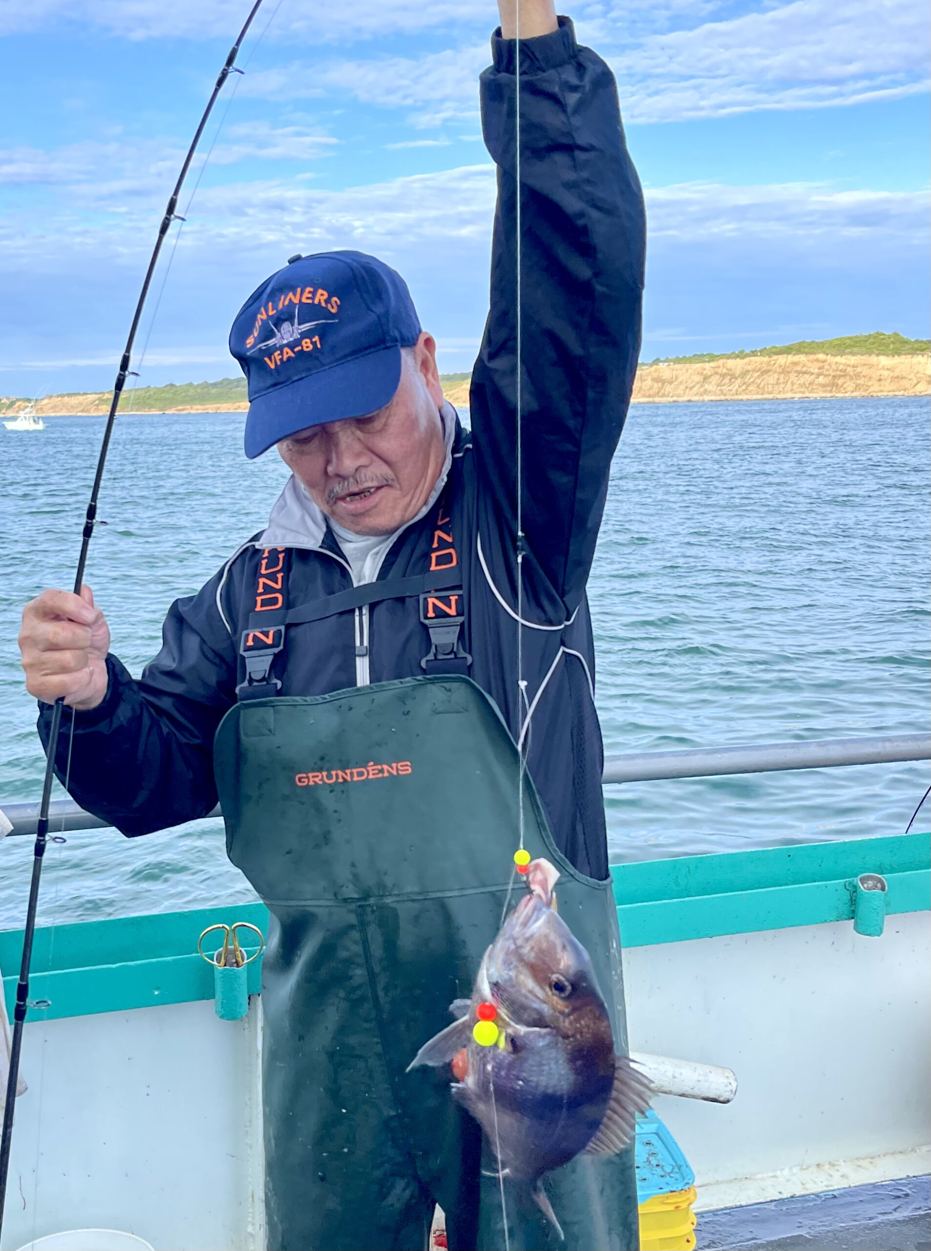 a person holding a fish on a boat in a body of water
