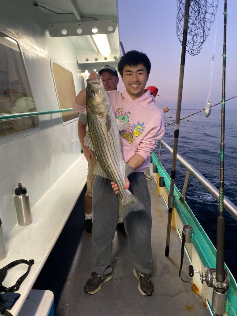 a person holding a fish on a boat