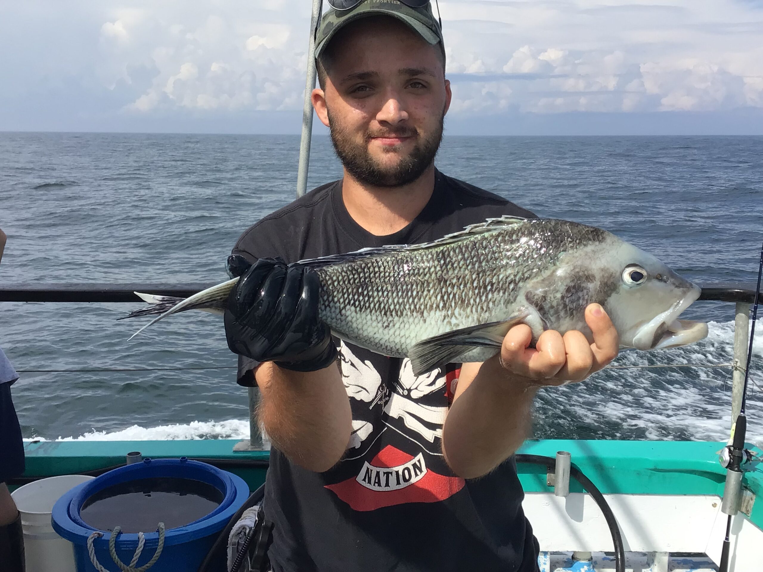 a man holding a fish on a boat in a body of water