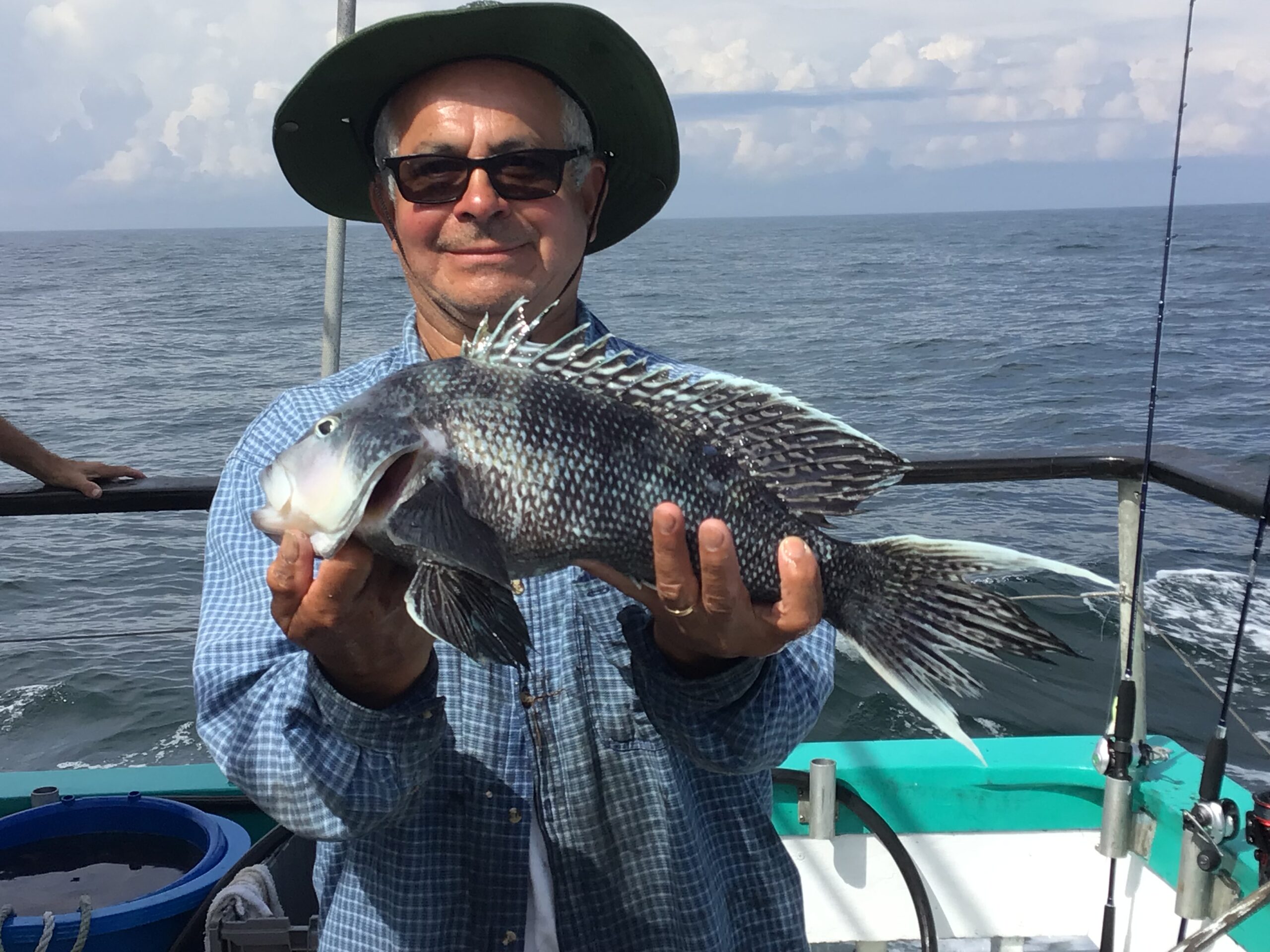 a person holding a fish on a boat in a body of water