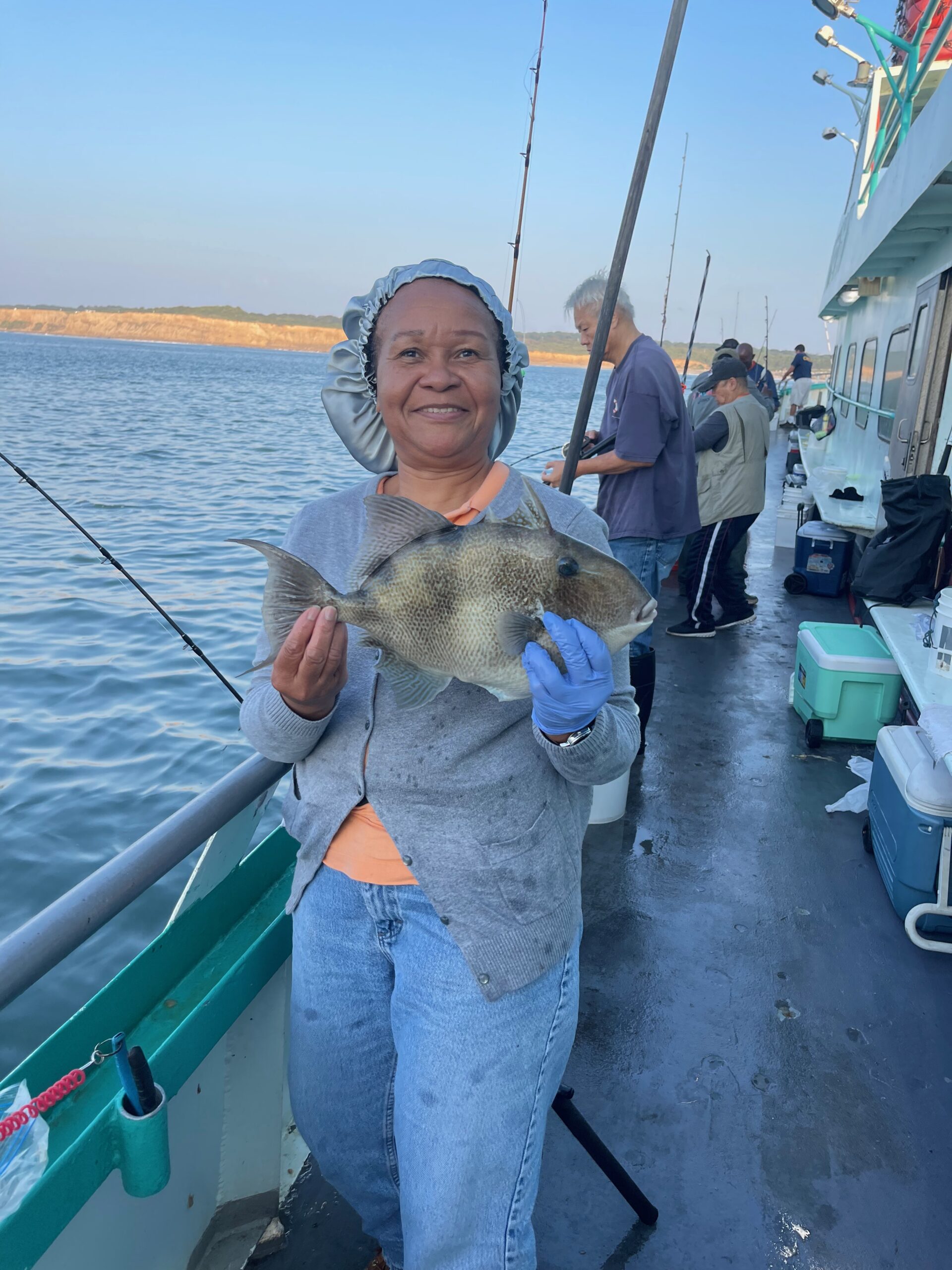 a person holding a fish on a boat in the water