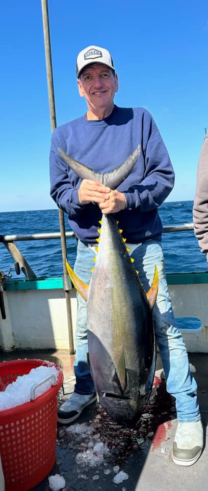 a man holding a fish in the water