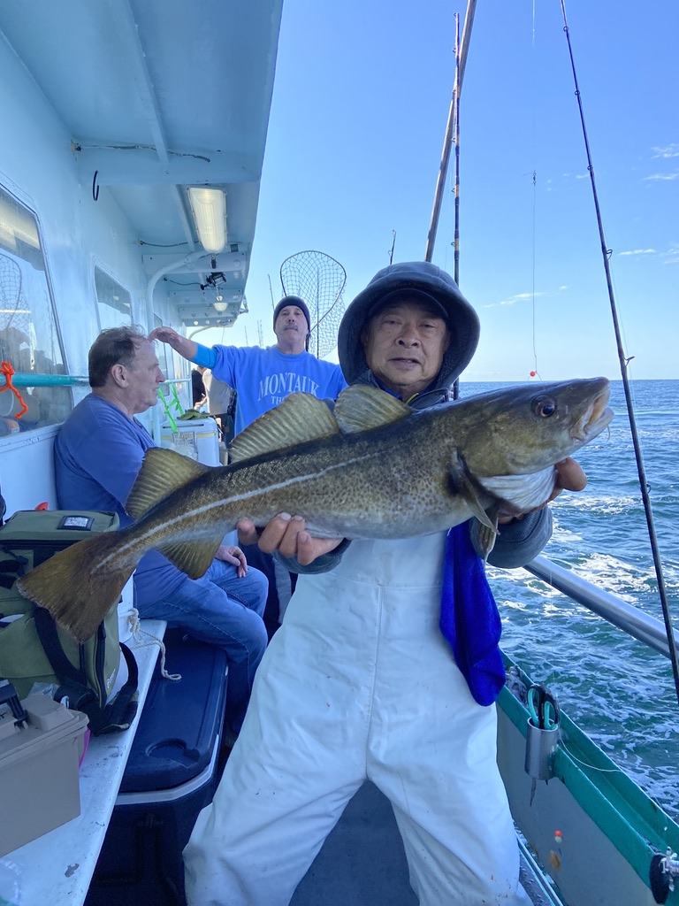 a person holding a fish on a boat