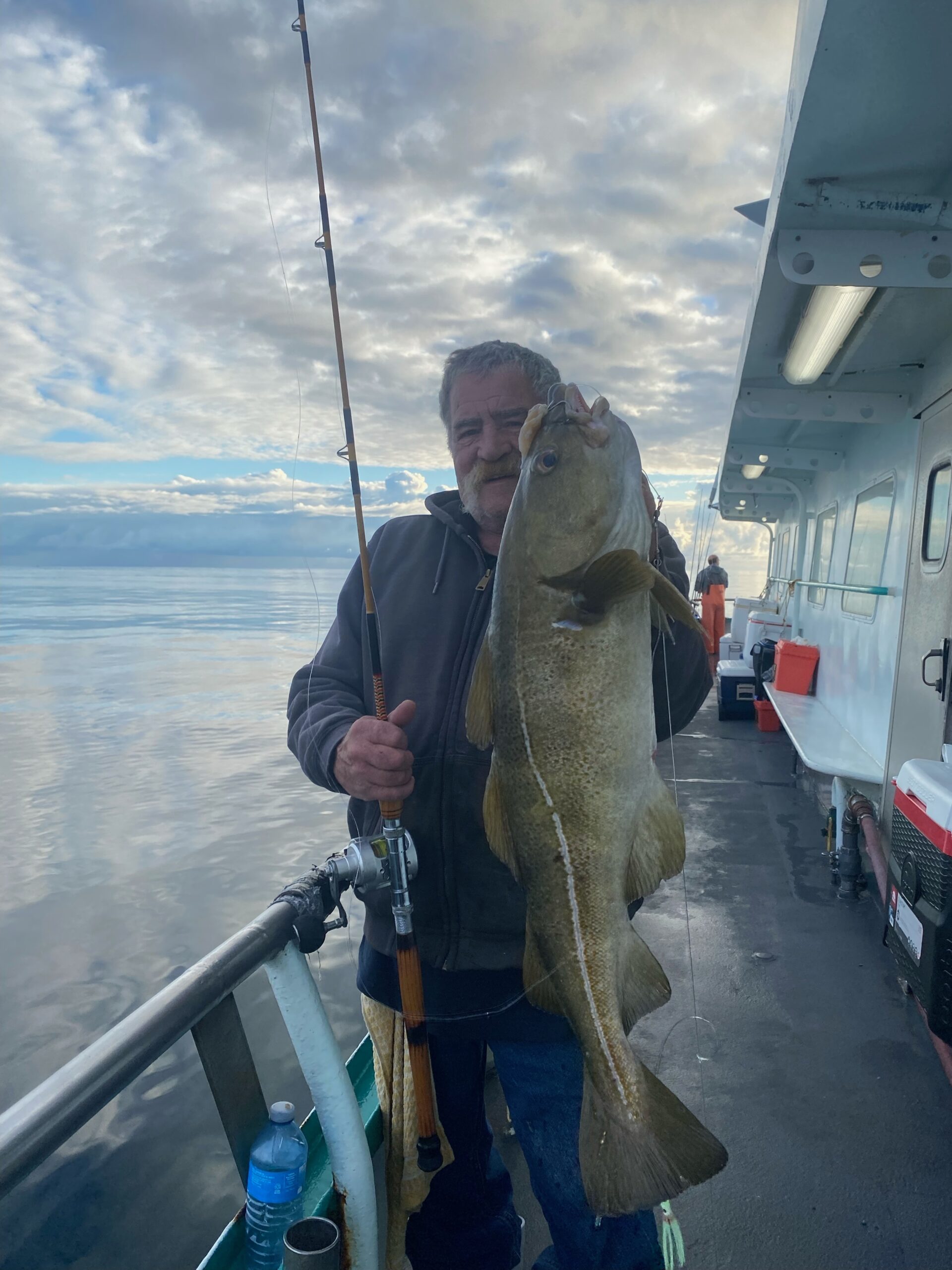 a person holding a fish on a boat in the water