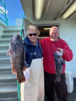 a man holding a fish in front of a building