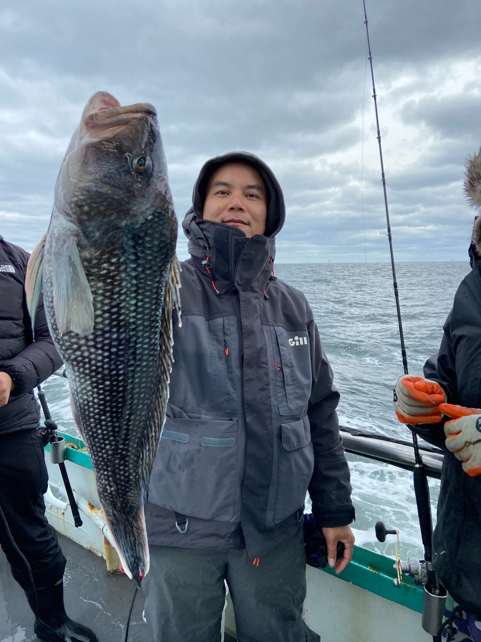 a group of people standing next to a person holding a fish