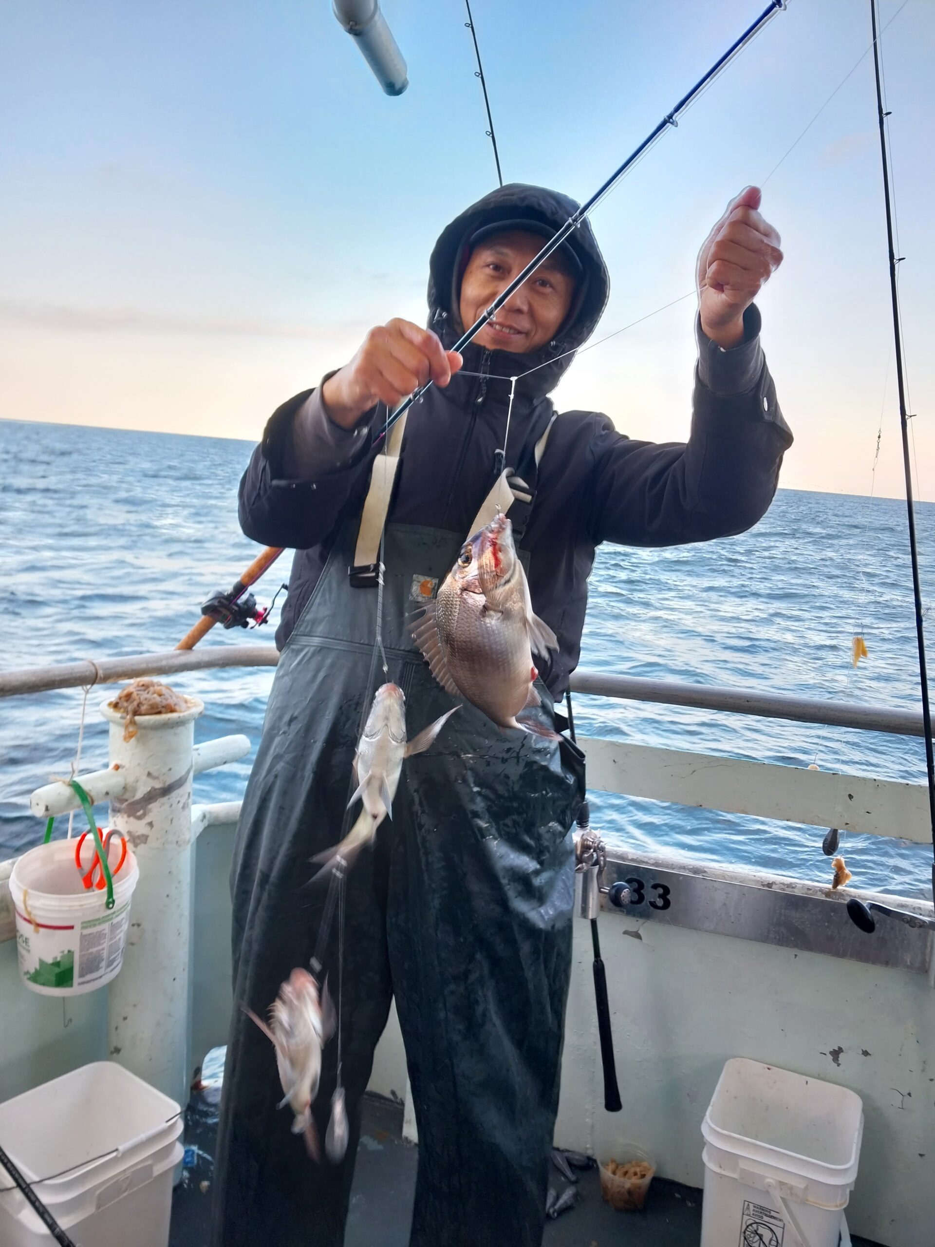 a person holding a fish on a boat in a body of water